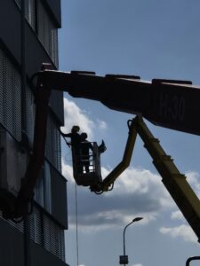 Mycie elewacji budynku z dwóch podnośników